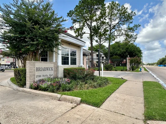a front view of a house with a yard and tree