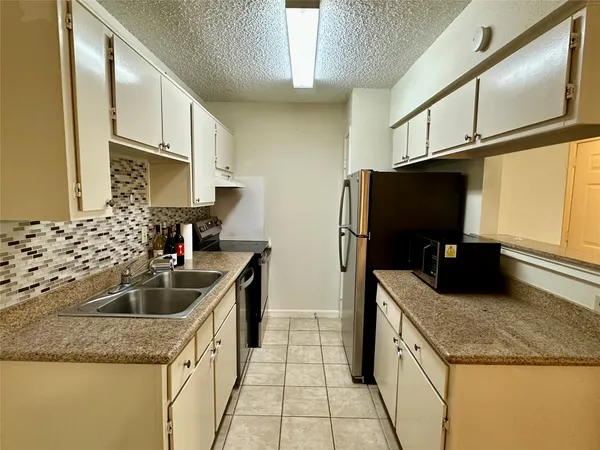 a kitchen with granite countertop a sink stainless steel appliances a counter top space and cabinets
