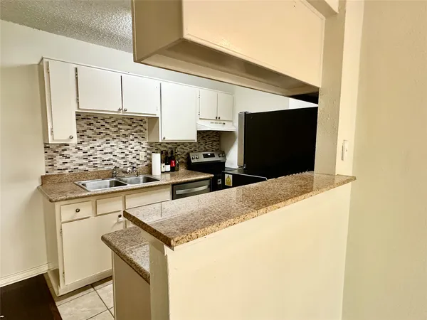 a kitchen with stainless steel appliances granite countertop a sink and a stove
