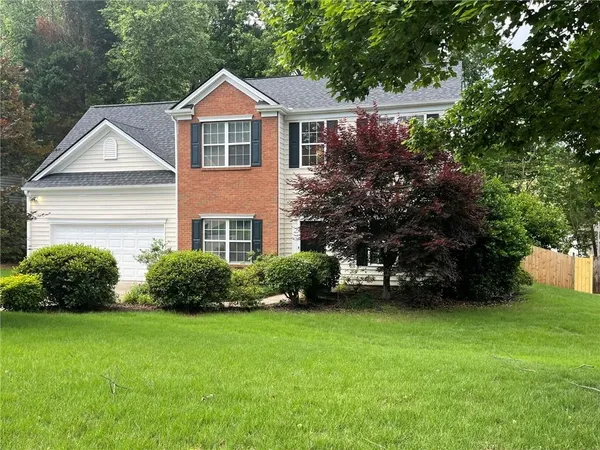 a front view of a house with a garden
