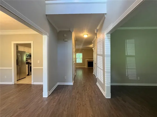 an empty room with wooden floor closet and windows
