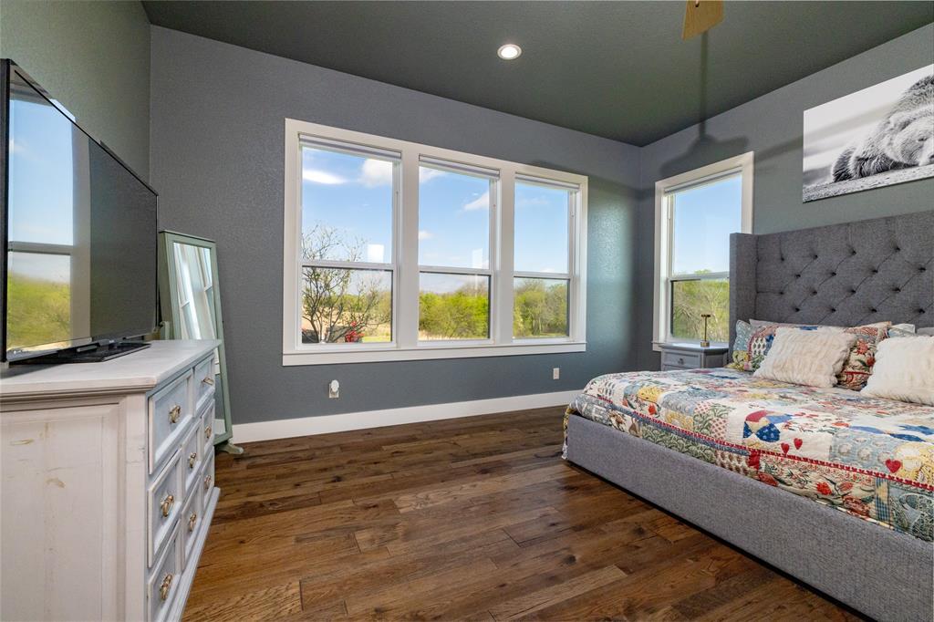 338 County Road 4223 Decatur, TX 76234 - Photo 23 of 37 Primary Bedroom with walls of windows providing natural light and black out shades as needed.