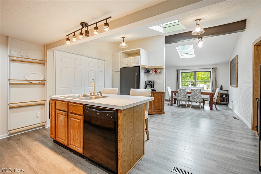 9315 Price Road Ravenna, OH 44266 - Photo 15 of 31 Kitchen featuring stainless steel fridge, a kitchen island with sink, pendant lighting, dishwasher, and a skylight
