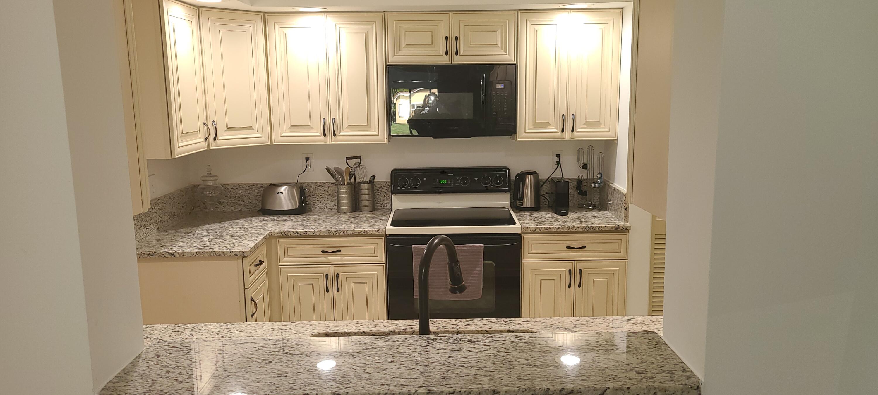 11105 Rios Road Boca Raton, FL 33498 - Photo 5 of 31 a kitchen with stainless steel appliances granite countertop a sink stove and cabinets