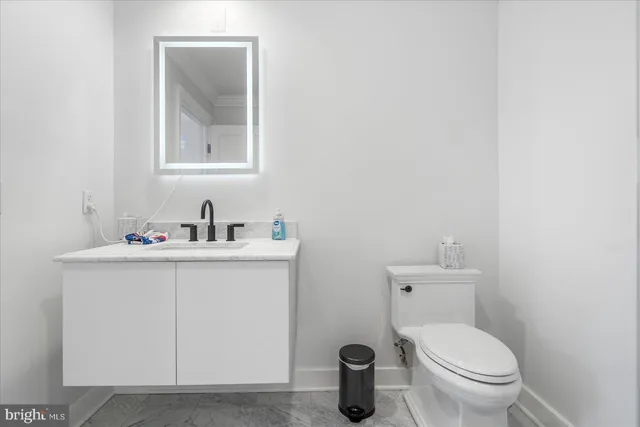 a bathroom with a toilet a sink and mirror
