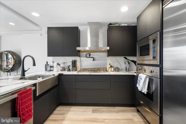 a kitchen with stainless steel appliances a sink stove and refrigerator
