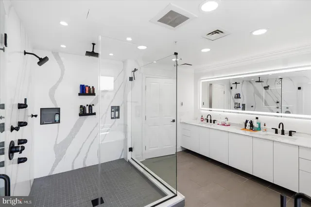 a large bathroom with a double vanity sink and mirror with shower