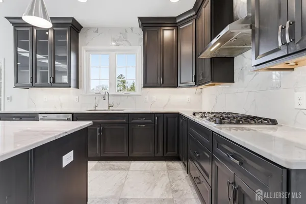 a kitchen with stainless steel appliances granite countertop a sink and a stove