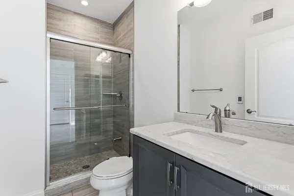 a bathroom with a sink a toilet and shower