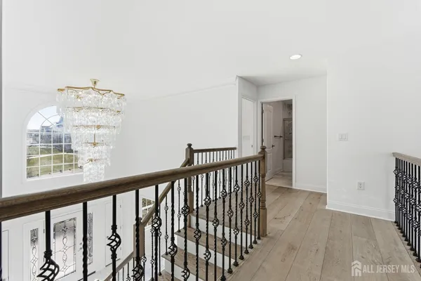 a view of a hallway with wooden floor and staircase