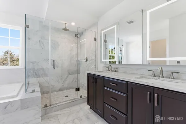 a bathroom with a granite countertop sink a toilet and shower