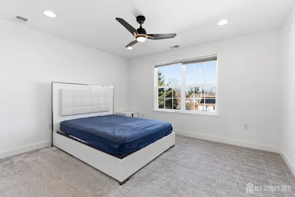 a living room with a window and a ceiling fan