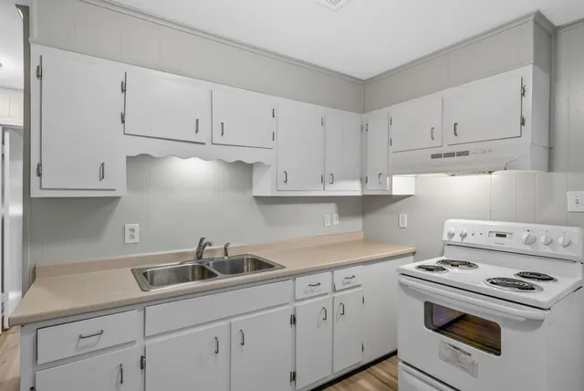 a kitchen with white cabinets and white appliances