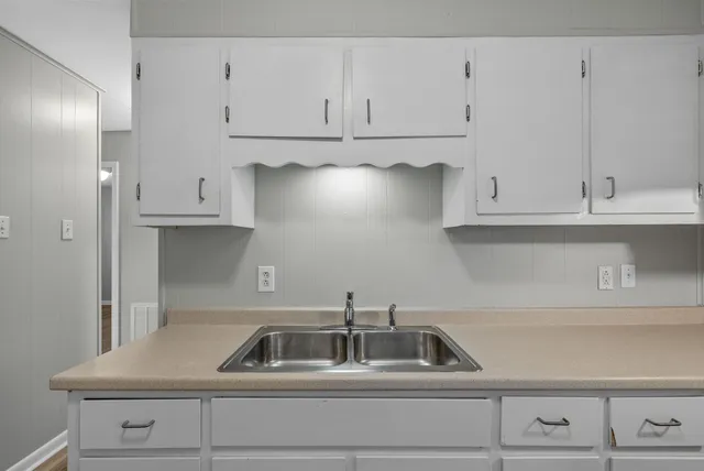 a kitchen with white cabinets and a sink