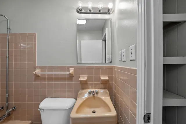 a bathroom with a toilet sink and mirror