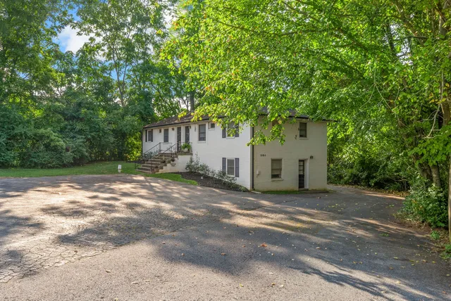 a view of a house with a tree and a yard