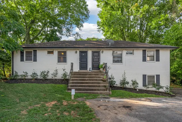 a view of a house with a yard and sitting area