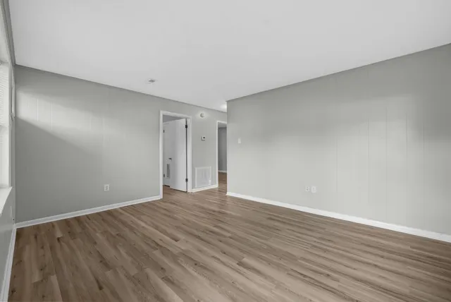a view of an empty room with wooden floor