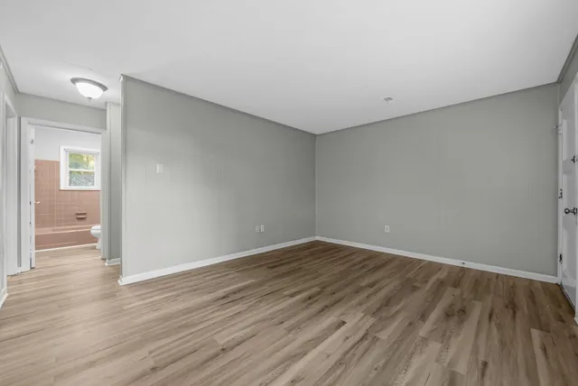 a view of an empty room with wooden floor