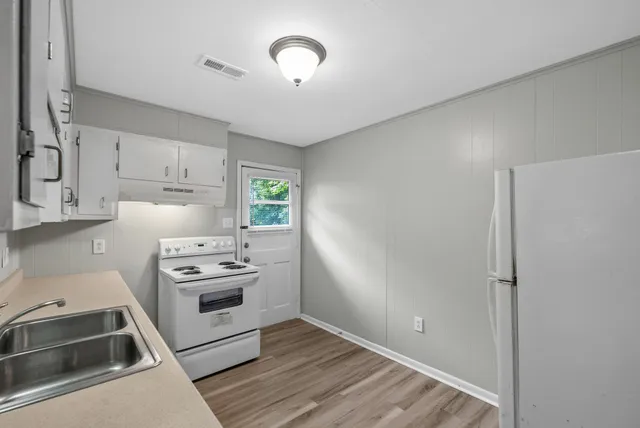 a kitchen with cabinets a sink and appliances