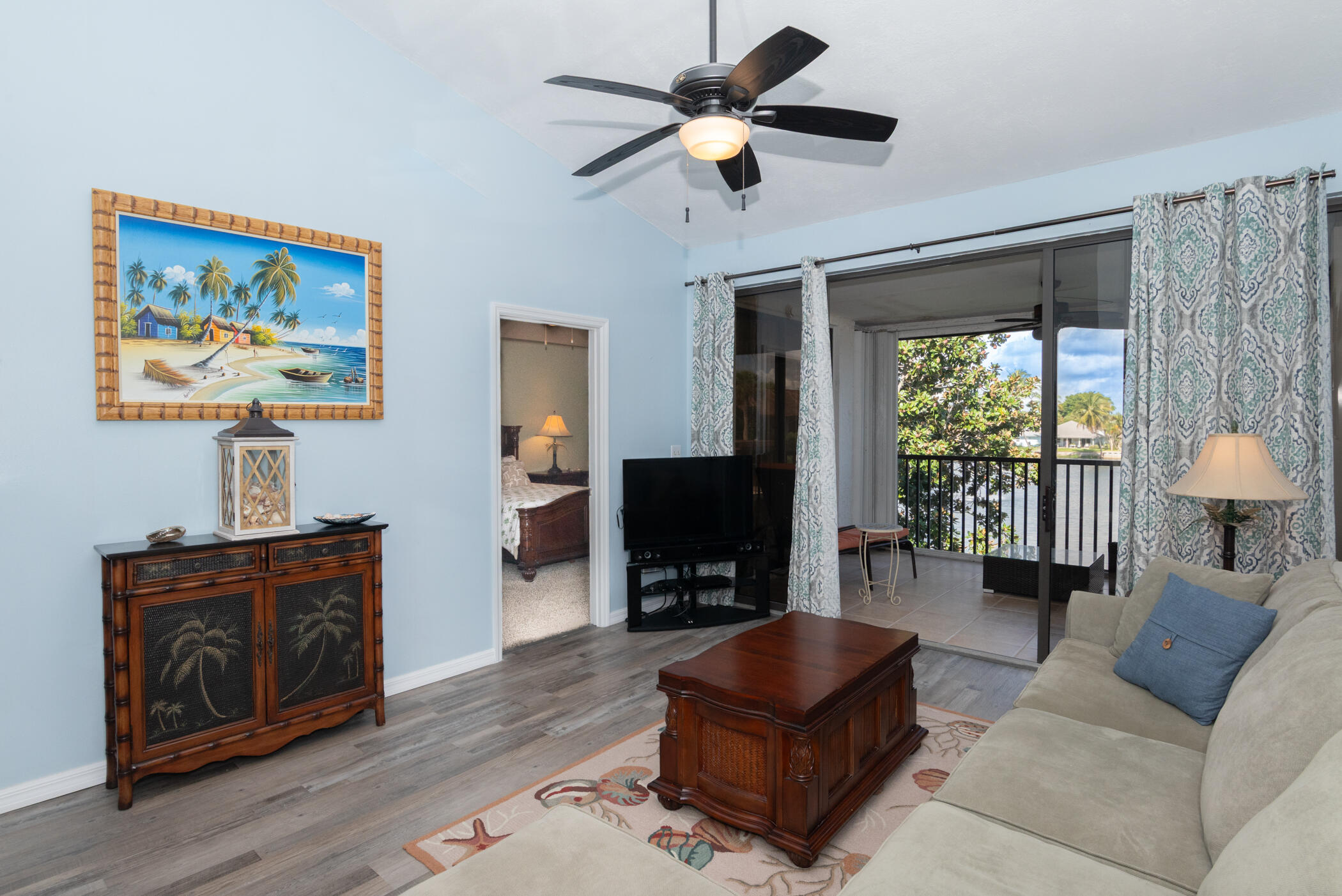 6041 Southeast Landing Way, Unit 17 Stuart, FL 34997 - Photo 13 of 37 a living room with furniture a ceiling fan and a flat screen tv