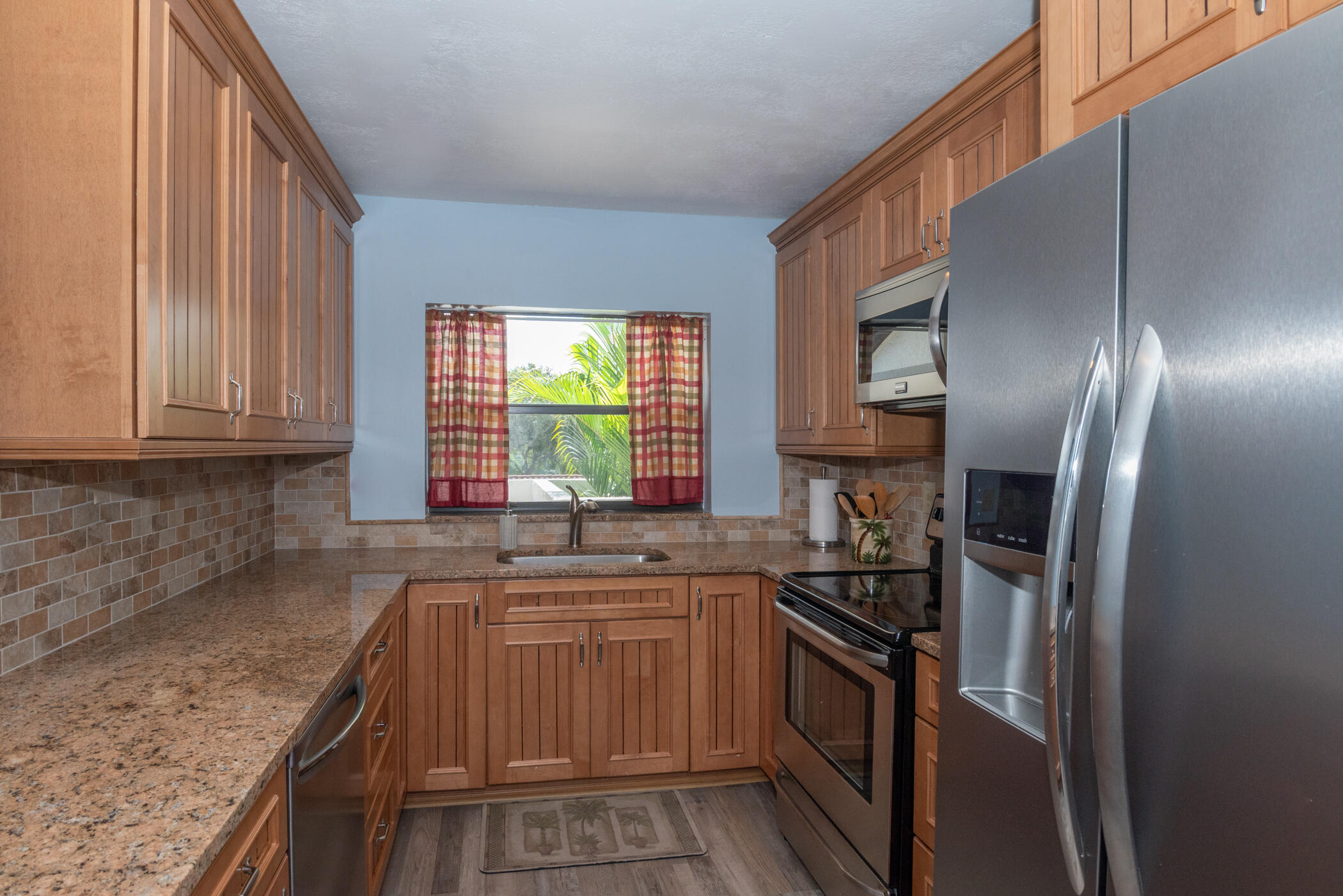 6041 Southeast Landing Way, Unit 17 Stuart, FL 34997 - Photo 4 of 37 a kitchen with stainless steel appliances granite countertop a sink stove and refrigerator