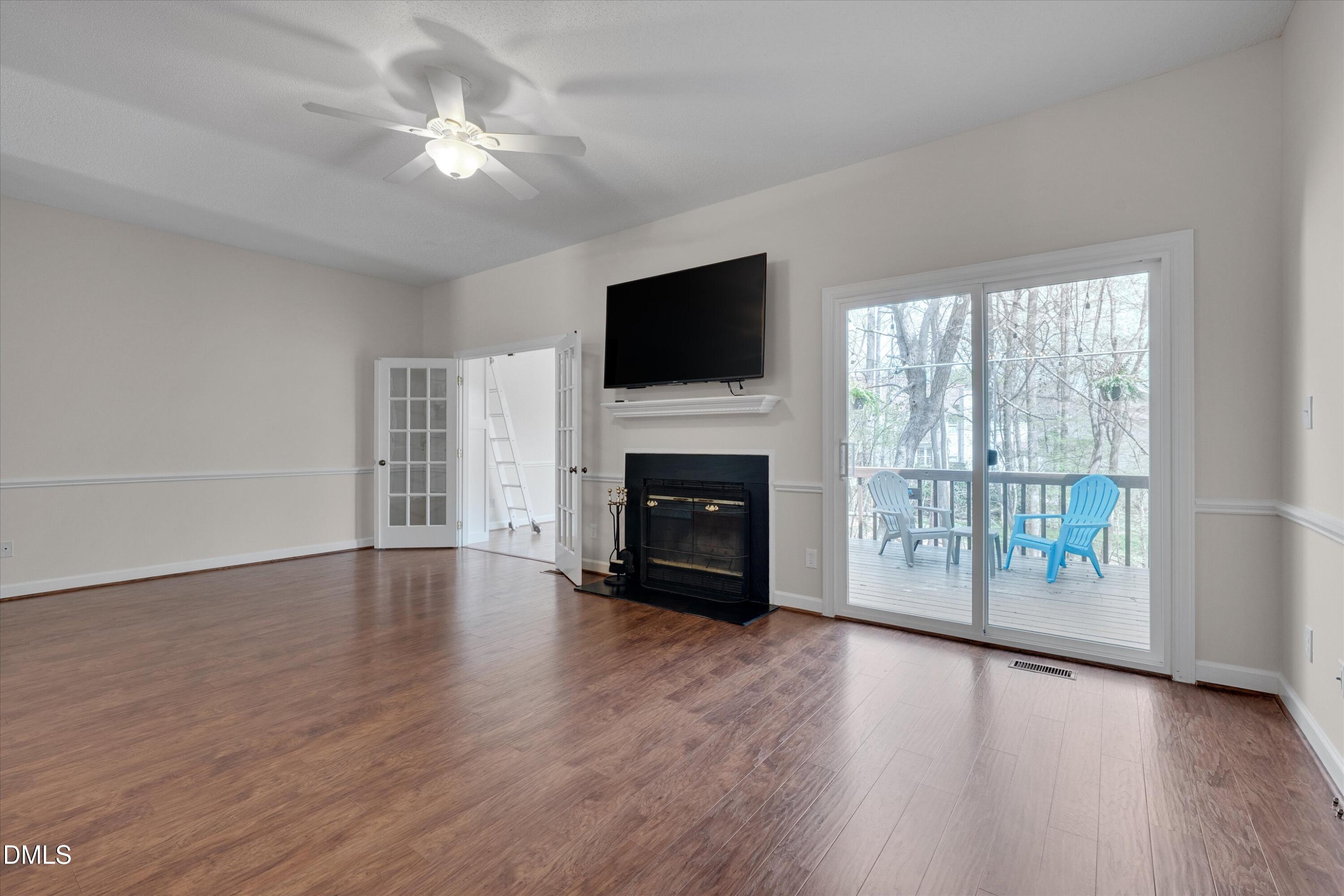 3 Preakness Drive Durham, NC 27713 - Photo 16 of 62 a view of a livingroom with a flat screen tv a fireplace and wooden floor