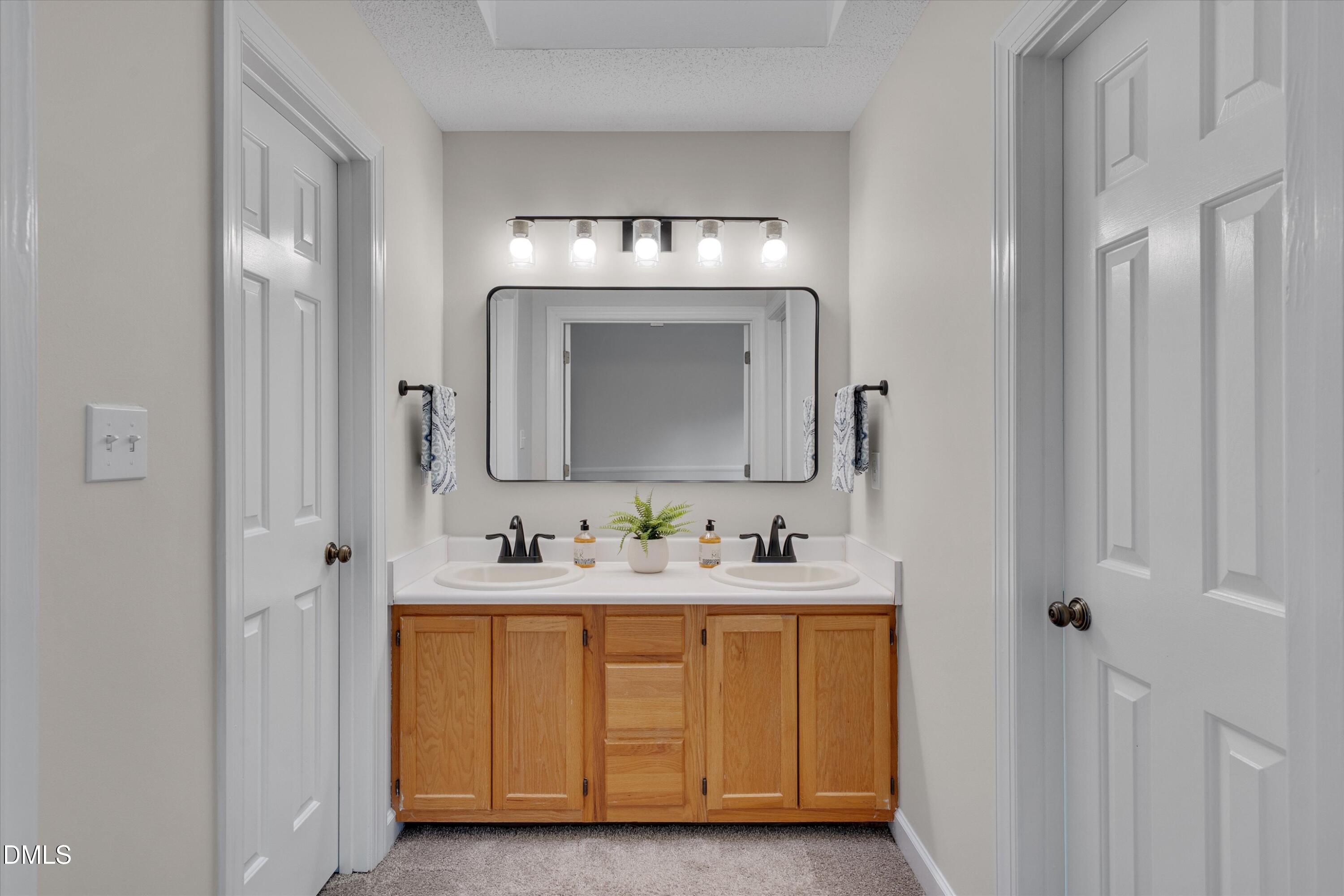 3 Preakness Drive Durham, NC 27713 - Photo 26 of 62 a bathroom with a double vanity sink and a mirror