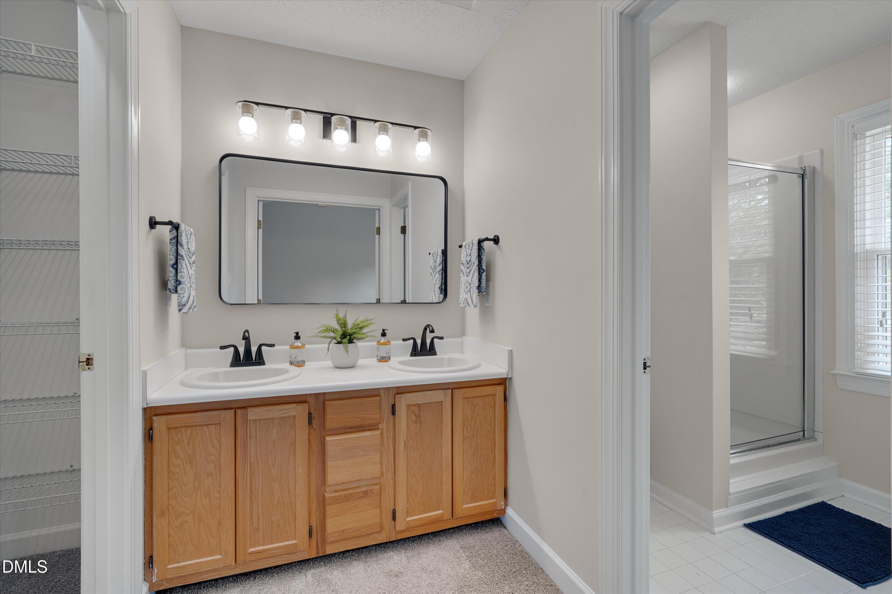 3 Preakness Drive Durham, NC 27713 - Photo 27 of 62 a bathroom with a double vanity sink and a mirror