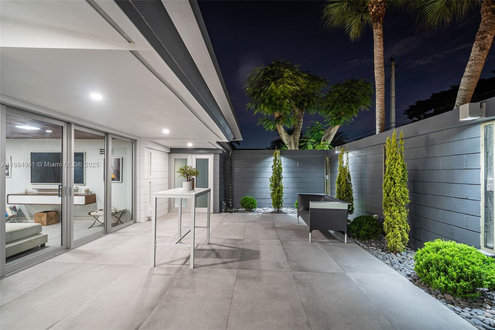 7550 Southwest 60th Street Miami, FL 33143 - Photo 42 of 64 a view of a patio with table and chairs potted plants and floor to ceiling window