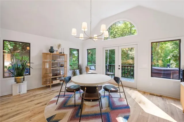 a view of a dining room with furniture a chandelier and wooden floor
