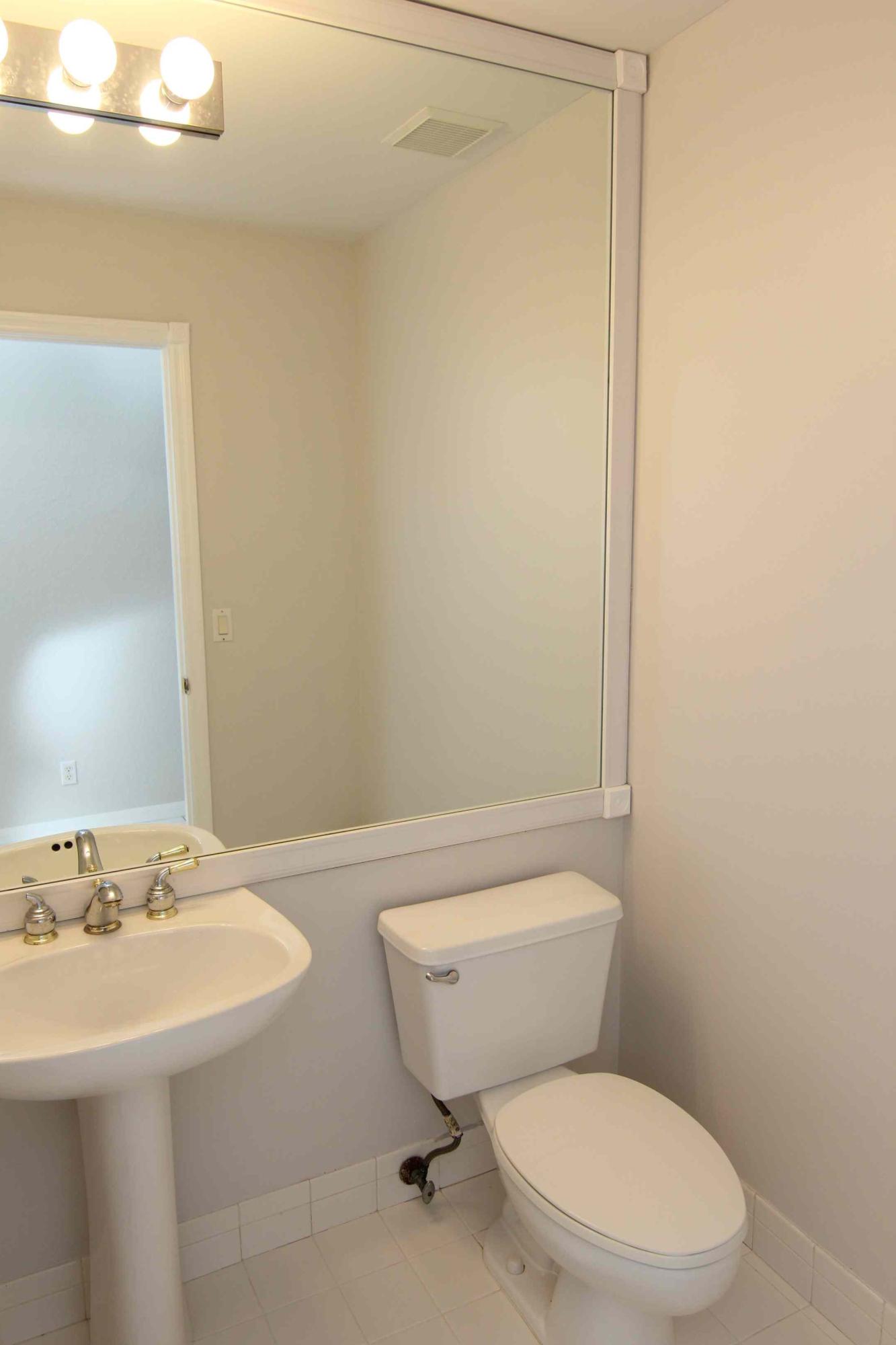 18540 Ocean Mist Drive Boca Raton, FL 33498 - Photo 12 of 37 a bathroom with a toilet a sink and mirror