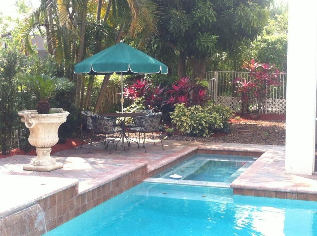 18540 Ocean Mist Drive Boca Raton, FL 33498 - Photo 25 of 37 a view of a backyard with sitting area and a garden