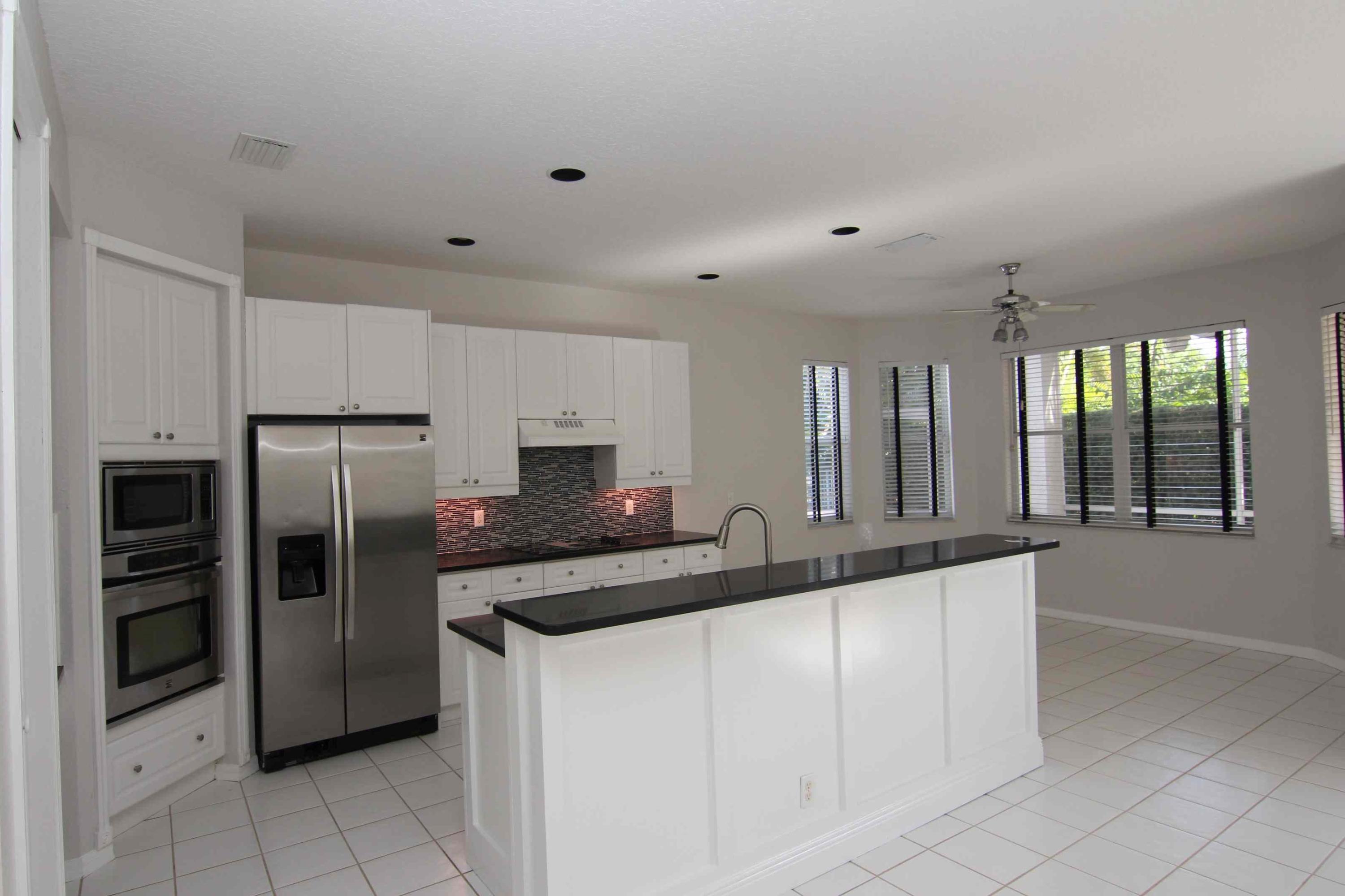 18540 Ocean Mist Drive Boca Raton, FL 33498 - Photo 4 of 37 a kitchen with granite countertop a refrigerator and a sink