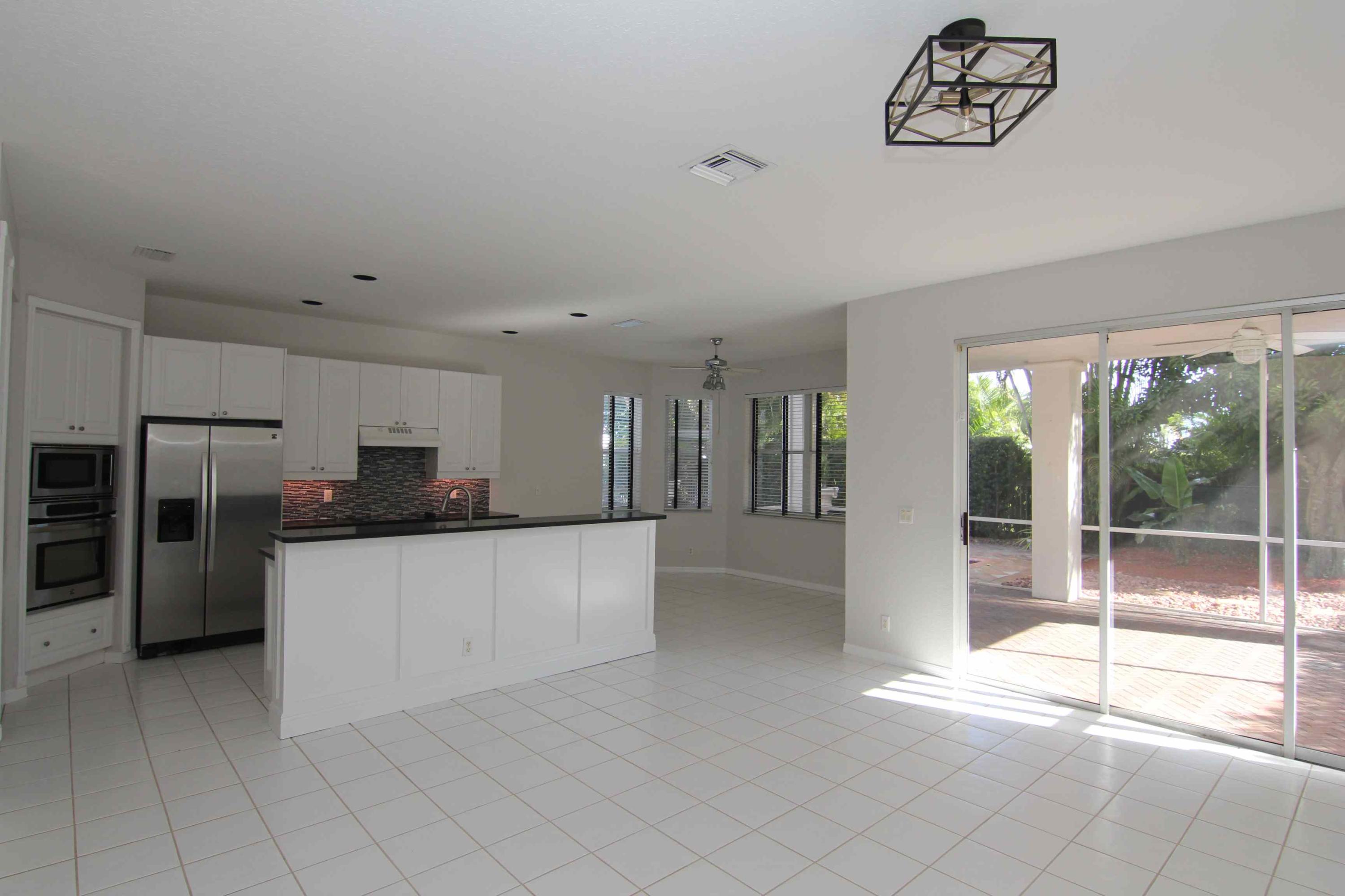 18540 Ocean Mist Drive Boca Raton, FL 33498 - Photo 5 of 37 a large white kitchen with a stove a refrigerator a sink and a large window