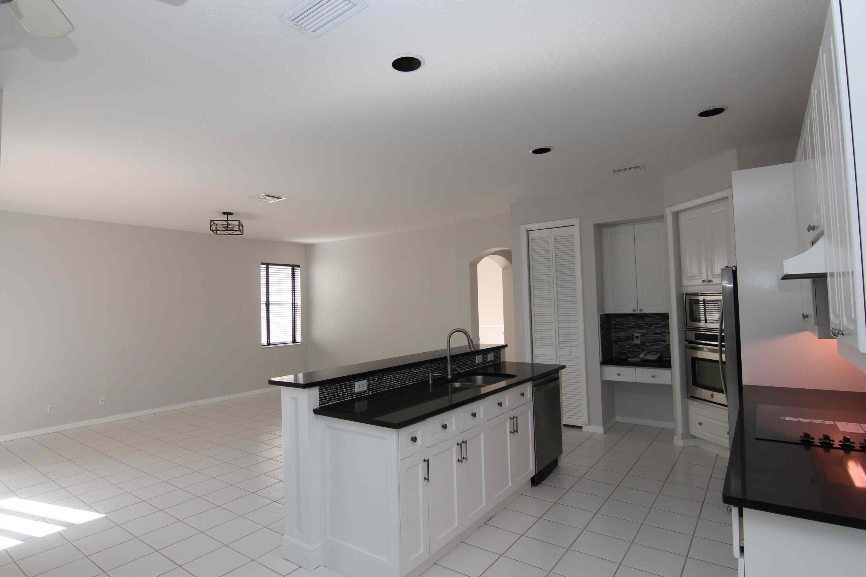 18540 Ocean Mist Drive Boca Raton, FL 33498 - Photo 6 of 37 a kitchen with granite countertop a refrigerator and a stove top oven