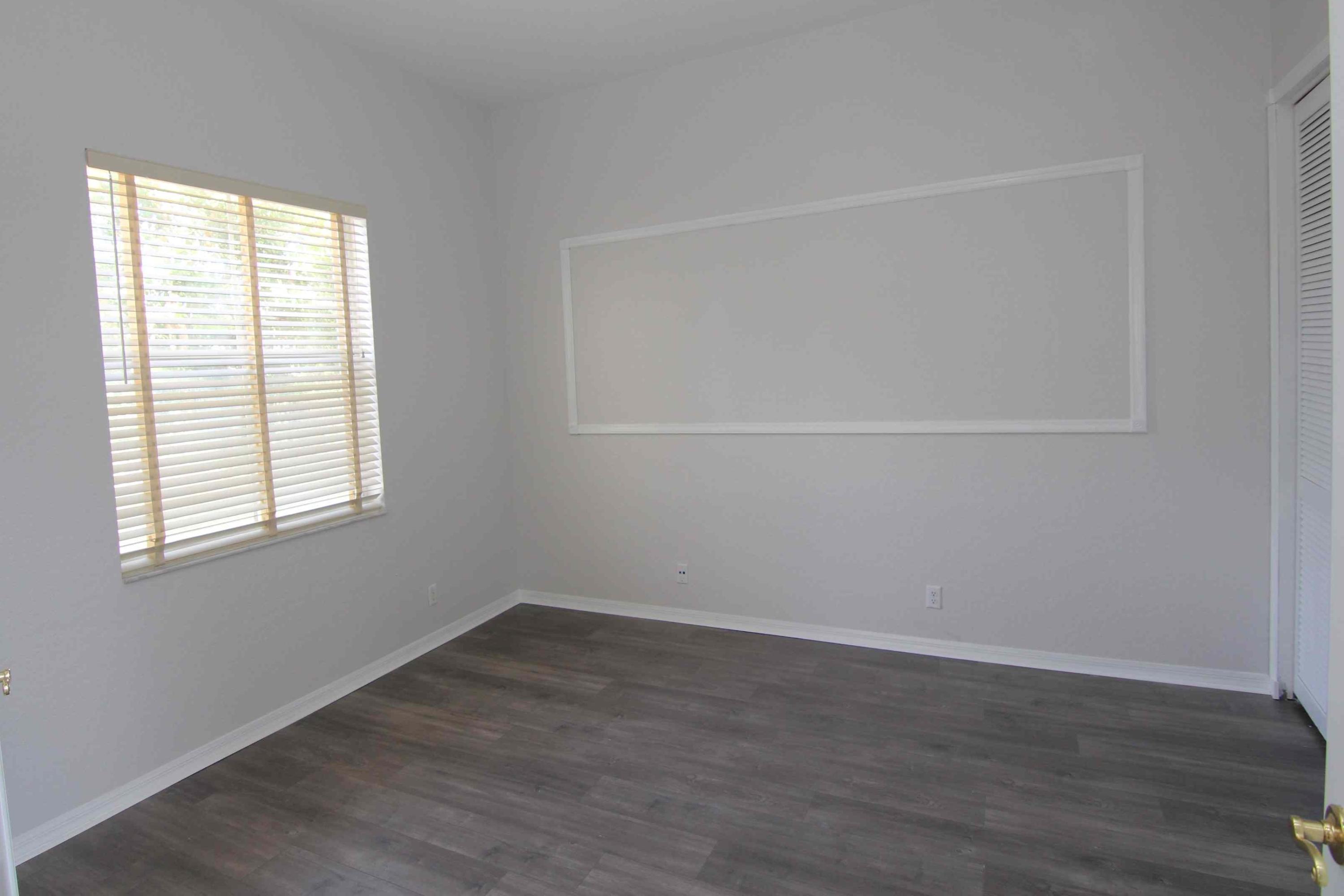 18540 Ocean Mist Drive Boca Raton, FL 33498 - Photo 10 of 37 an empty room with wooden floor and windows
