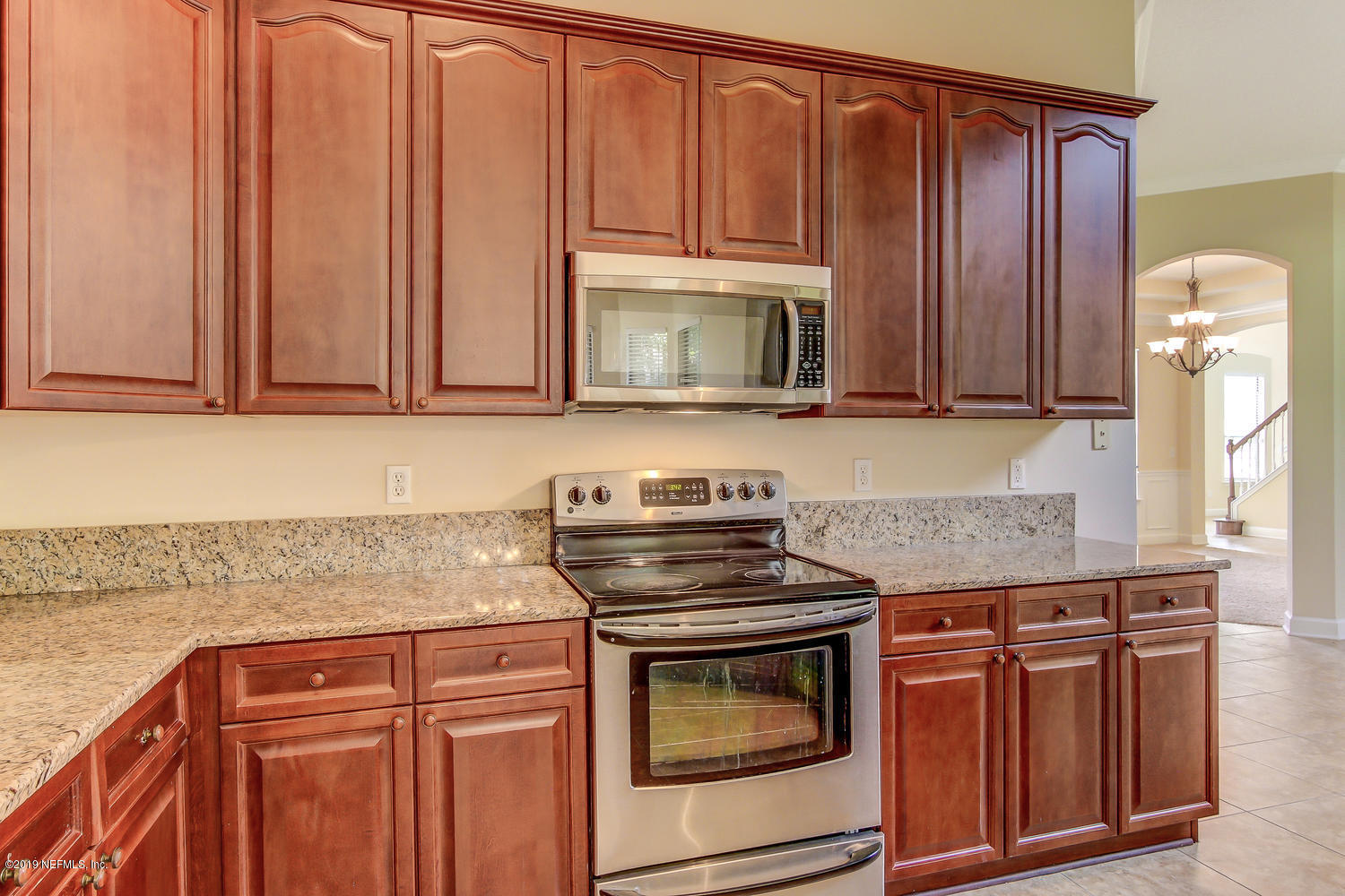 3993 Reds Gait Lane Jacksonville, FL 32223 - Photo 26 of 72 a kitchen with granite countertop wooden cabinets and a stove top oven