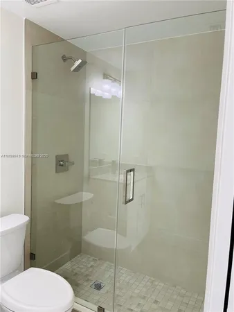 a bathroom with a toilet and a shower