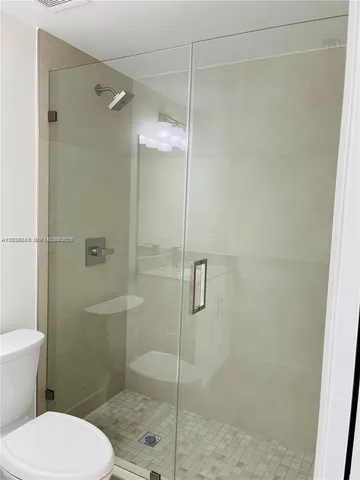 a bathroom with a toilet and a shower