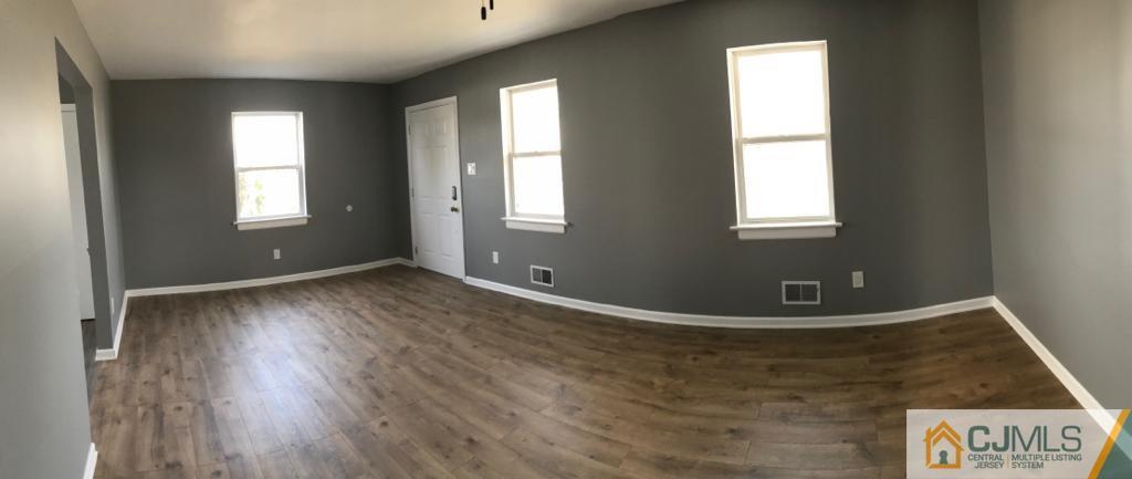 902 Salem Road Burlington, NJ 08016 - Photo 3 of 17 an empty room with wooden floor and windows