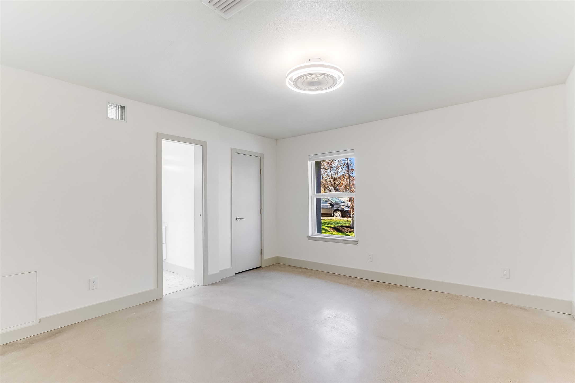 10101 Rutland Village East Austin, TX 78758 - Photo 14 of 26 Primary bedroom featuring baseboards, concrete flooring and upscale ceiling fan