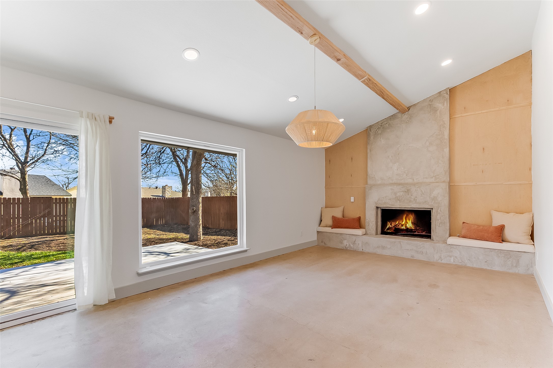 10101 Rutland Village East Austin, TX 78758 - Photo 6 of 26 Family room featuring lofted ceiling with beams, a large fireplace, polished concrete flooring, modern light fixture and recessed lighting.