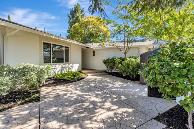 a front view of a house with a yard and potted plants
