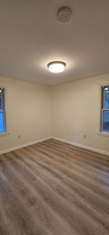 403 South Main Street, Unit 1 Sharon, MA 02067 - Photo 9 of 16 an empty room with wooden floor and windows