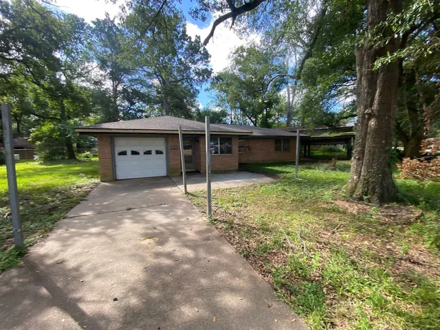 a view of a house with backyard and trees