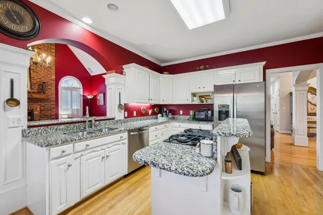 a kitchen with stainless steel appliances granite countertop a sink and cabinets