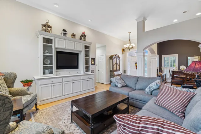 a kitchen with stainless steel appliances granite countertop a kitchen island a stove a refrigerator white cabinets a dining table and chairs