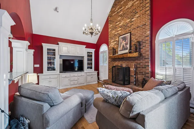 a dining room with furniture a chandelier and wooden floor