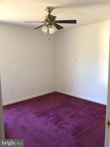 an empty room with a ceiling fan and a window